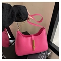Detail of fuchsia leather handbag with gold metal clasp and chain on a stylish vanity - Rose Red