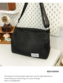 Detailed view of black canvas crossbody bag with durable zippers and adjustable strap - Black