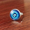 Silberner Evil Eye Ring mit blauem Glaskristall auf dunklem Holzgrund-Hintergrund - Blaue Riffelung (JY007909-2)