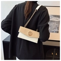 Detail of elegant two-tone woven shoulder bag with gold chain and M buckle - White