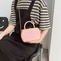 Pink hexagonal crossbody bag with gold metal frame and twisted handle shown on model - Pink
