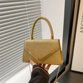 Elegant gold sequin handbag with metal V-clasp and chain strap shown in hand - Gold