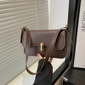 Bolso bandolera minimalista marrón oscuro con hebilla dorada en entorno moderno - Marrón