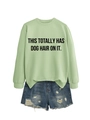 Detail of light green sweatshirt with 'THIS TOTALLY HAS DOG HAIR ON IT' text and denim shorts - Olive Green (Black Font)