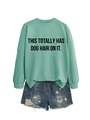 Detail of mint green sweatshirt with black slogan paired with frayed denim shorts - Light Green (Black Font)