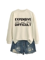 Detail of loose round neck sweatshirt with 'EXPENSIVE' print and distressed denim shorts - Sand (Black Print)