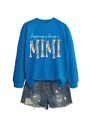 Flat lay of blue Happiness is being mimi sweatshirt with distressed denim shorts - Lake Blue (White Letters Graphic)