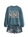 Flat lay of a blue sweatshirt with Mimi lettering and distressed denim shorts - Blue (White Graphics)