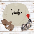Detail view of cream sweatshirt with black Smile text and red heart patch on sleeve - S / Sand (Black Font)