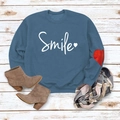 Detail of blue smile sweatshirt with white text and red heart patch on the sleeve - Blue (White Font)
