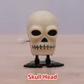 Wind-up skull toy in off-white plastic with black feet for Halloween festive fun - Skull
