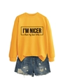 Detail of yellow sweatshirt print reading I'M NICER than my face looks with denim shorts - Yellow (Black Font)