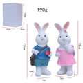 Pair of Easter bunny resin figurines in blue and pink outfits with packaging box - Pair of Backpack Bunnies