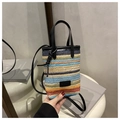 Detalle del bolso bandolera tejido a rayas de colores con asa de cuero negro y parche de moda - Negro