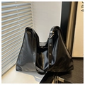 Detail of glossy black tote bag with metal eyelets on shoulder straps and silver buckle - Black
