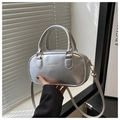 Detail shot of silver PU leather handbag showing FASHION & BAGS text and metallic texture - Silver