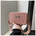 Close-up of pink crossbody bag with M-pattern print and stylish wide woven strap - Pink