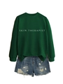 Gros plan sur l'imprimé Skin Therapist du sweat-shirt vert et short en jean usé - Vert Foncé (Police Blanche)