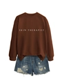 Détail du texte Skin Therapist sur sweat marron et mini-short en jean avec déchirures - Café (Police Blanche)