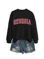 Detailed view of black Georgia print sweatshirt and distressed denim shorts with frayed edges - Black