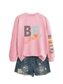 Détail du sweat rose avec imprimé manche et short en jean bleu délavé en kit - Rose