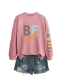 Détail du sweat rose et short en jean avec texte YOU ARE ENOUGH sur la manche gauche - Or rose