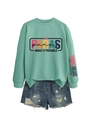 Close-up of mint green sweatshirt with PARAS logo print and distressed denim shorts - Light Green (Black Graphic)