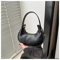 Detail of a black crescent handbag featuring a matte finish and elegant gold hardware - Black