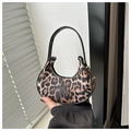 Macro detail of the leopard print texture and golden metal hardware on a crescent bag - Leopard Brown