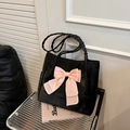 Elegante bolso tote de terciopelo negro con lazo rosa grande y correas trenzadas - Negro