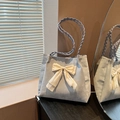 Elegante bolso tote azul claro con lazo crema y asa tejida sobre un fondo con estilo - Azul