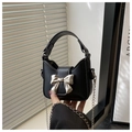 Close-up of black mini PU leather bag with large silver metal bow and chain strap - Black