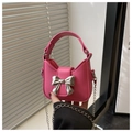 Detailed view of mini pink handbag featuring silver metal bow and fine chain strap - Rose Pink