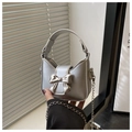 Close-up of silver mini handbag with metallic bow decoration and round handle - Silver