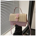 Detalle del bolso bandolera de cuero rosa y paja tejida con una hebilla de metal dorada en forma de H - Rosa