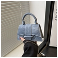 Gros plan du mini sac à main sablier en denim avec chaîne argentée et détail d'anneau - Bleu
