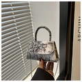 Dettaglio mini borsa pitonata con chiusura a fiocco argento e tracolla a catena - Bianco