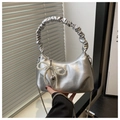 Detail of silver handbag with pearl bow pendant and metallic heart charm on chain strap - Silver