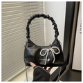 Detail of black croissant bag with pearl bow, heart pendant, and ruched handle - Black