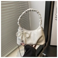 Detailed close-up of white pleated cloud bag with pearl bow and silver chain strap - White