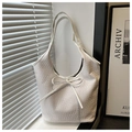 Detail of white woven textured tote bag with a decorative ribbon bow on the front - White