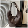 Detail of dark brown tote bag featuring bow tie strap and textured synthetic leather surface - Coffee