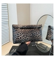 Detail view of leopard print clutch bag with silver circular metal fasteners and chic fold closure - Brown