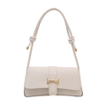 Chic cream woven underarm bag with gold buckle and knotted strap detail on white background - White