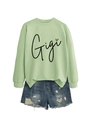 Détail de l'imprimé cœur léopard Gigi sur sweat-shirt vert clair avec short en jean - Vert olive (Motif noir)