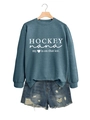 Details des petrolfarbenen Hockey-Sweatshirts mit zerrissenen Jeans-Shorts am Bügel - Blau (Weiße Schrift)