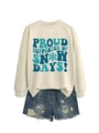 Mise à plat d'un sweat crème avec motif Proud Supporter of Snow Days et short en jean vieilli - Sable