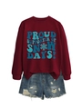 Détail de l'imprimé graphique bleu sur un sweat bordeaux avec flocons et motifs de sapins - Bordeaux