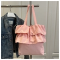 Bolso tote de lona rosa con volantes colgado con chaqueta vaquera y fondo de puerta blanca - Rosa