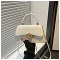Detalle del bolso de cuero blanco crema con cierre dorado y asa superior elegante - Blanco